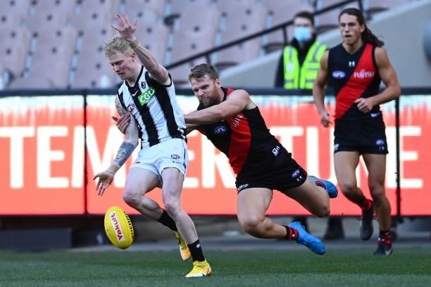 John Noble of the Magpies is tackled by Jake Stringer of the Bombers during the round 23 AFL match between Essendon Bombers and Collingwood Magpies...