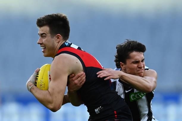 Zach Merrett of the Bombers is tackled by Trent Bianco of the Magpies during the round 23 AFL match between Essendon Bombers and Collingwood Magpies...