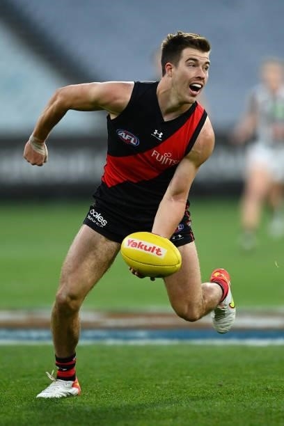 Zach Merrett of the Bombers handballs during the round 23 AFL match between Essendon Bombers and Collingwood Magpies at Melbourne Cricket Ground on...