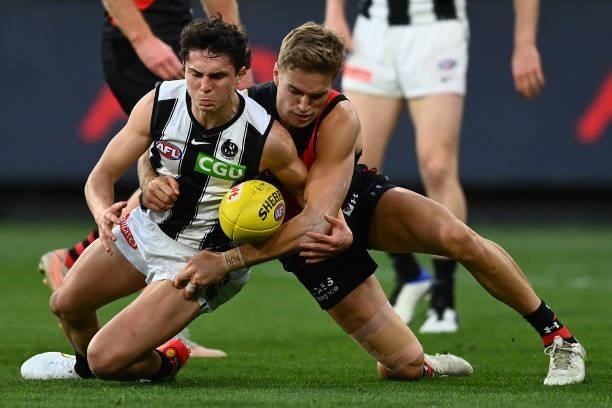 Trent Bianco of the Magpies is tackled by Matt Guelfi of the Bombers during the round 23 AFL match between Essendon Bombers and Collingwood Magpies...