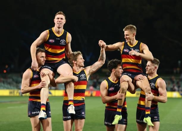 Tom Lynch of the Crows and David Mackay of the Crows are chaired off the ground during the round 23 AFL match between Adelaide Crows and North...