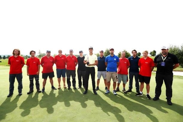 Johannes Veerman of United States poses with the trophy after winning the D+D Real Czech Masters as greenkeepers pose with him for a photograph...