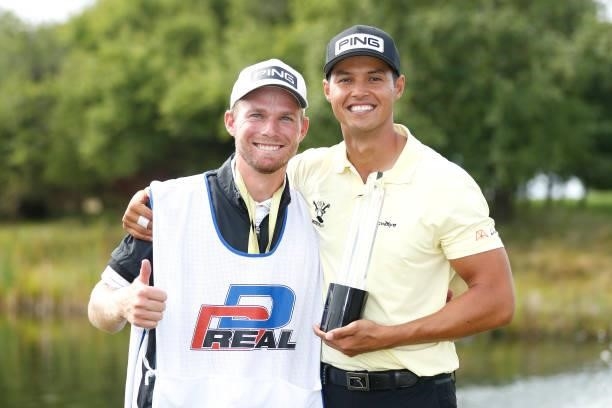 Johannes Veerman of United States poses with the trophy after winning the D+D Real Czech Masters alongside his caddie, Steve Tooby during Day Four of...