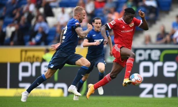 Taiwo Awoniyi of 1.FC Union Berlin breaks away whilst under pressure from Kevin Vogt of TSG 1899 Hoffenheim during the Bundesliga match between TSG...