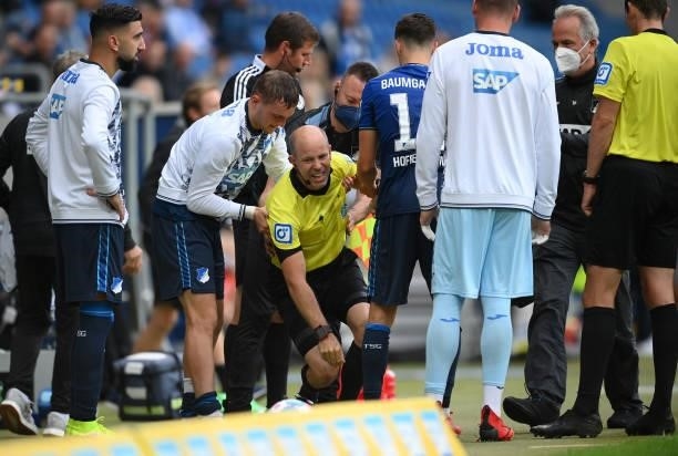 Assistant Referee, Mike Pickel reacts appears to be injured after colliding with Christoph Baumgartner of TSG 1899 Hoffenheim during the Bundesliga...