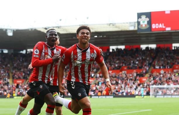 Che Adams of Southampton celebrates with Romain Perraud and Moussa Djenepo during the Premier League match between Southampton and Manchester United...