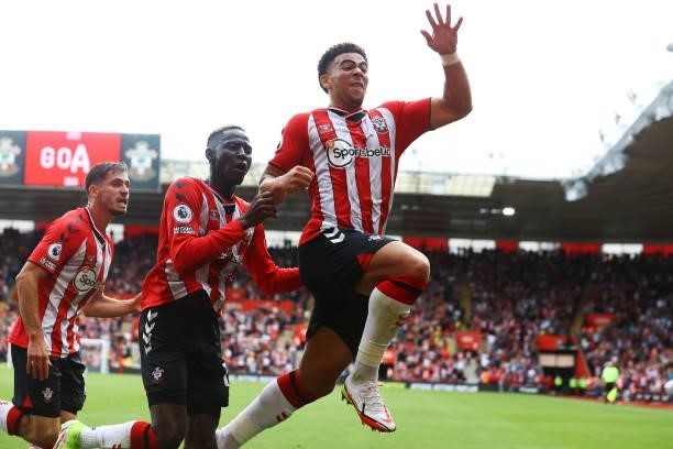Che Adams of Southampton celebrates with Romain Perraud and Moussa Djenepo during the Premier League match between Southampton and Manchester United...