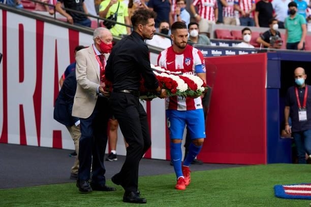 Koke and Diego Simeone head coach of Club Atletico de Madrid with a bouquet of flowers for the fans who have died during the COVID-19 pandemic ahead...