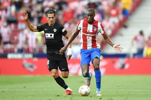 Geoffrey Kondogbia of Atletico Madrid breaks away from Pere Milla of Elche during the LaLiga Santander match between Club Atletico de Madrid and...