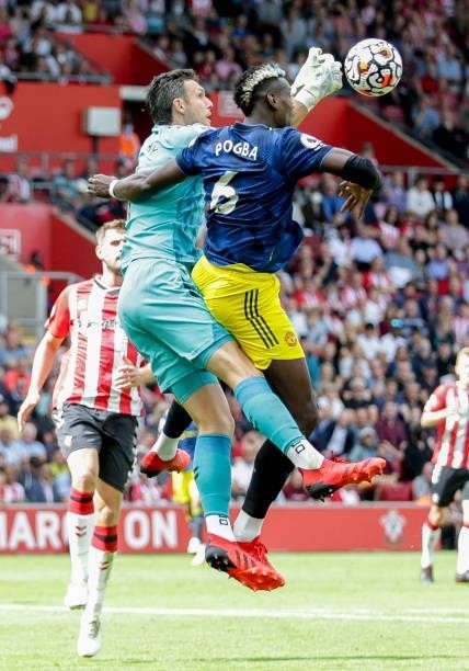 Alex McCarthy of Southampton punches clear from Paul Pogba of Manchester United during the Premier League match between Southampton and Manchester...