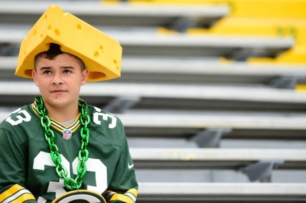 Green Bay Packers fan wearing a cheesehead sits in the stands before a preseason game against the New York Jets at Lambeau Field on August 21, 2021...
