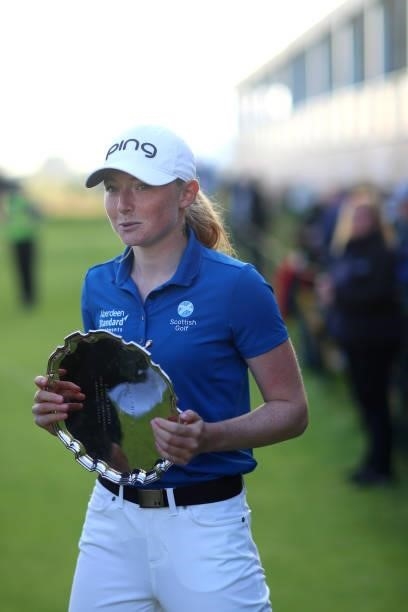 Leading Amateur, Louise Duncan of Scotland holds her trophy upon leaving the on the eighteenth green during Day Four of the AIG Women's Open at...