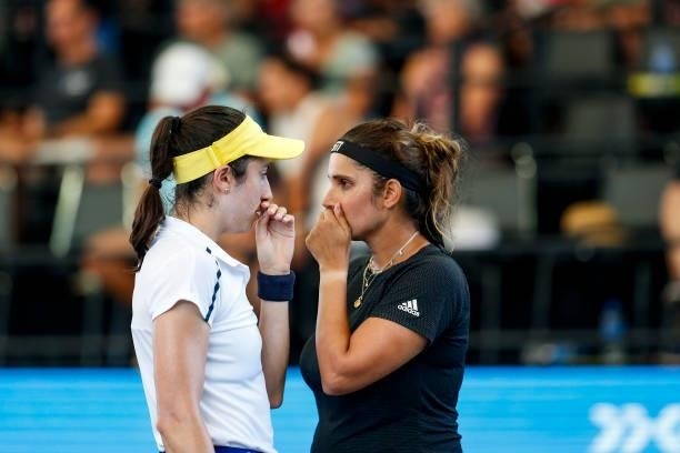 Christina McHale of USA and Sania Mirza of India whisper to each other during their doubles match against Oksana Kalashnikova of Georgia and Andreea...