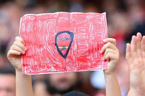 Fan holds a banner during the Premier League match between Arsenal and Chelsea at Emirates Stadium on August 22, 2021 in London, England.