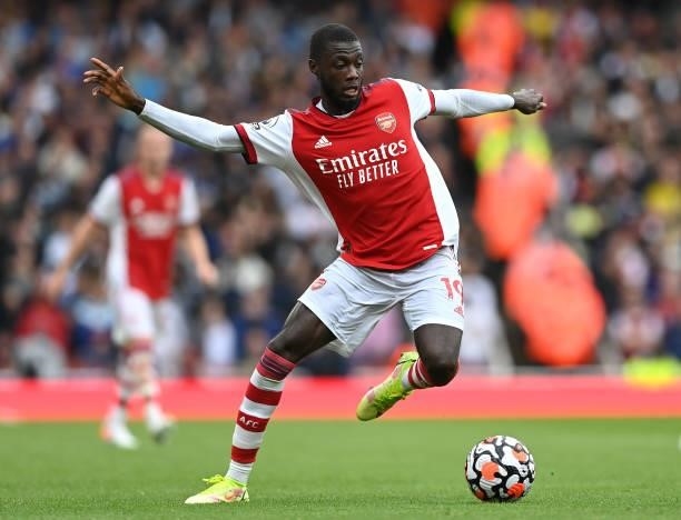 Nicolas Pepe of Arsenal runs with the ball during the Premier League match between Arsenal and Chelsea at Emirates Stadium on August 22, 2021 in...