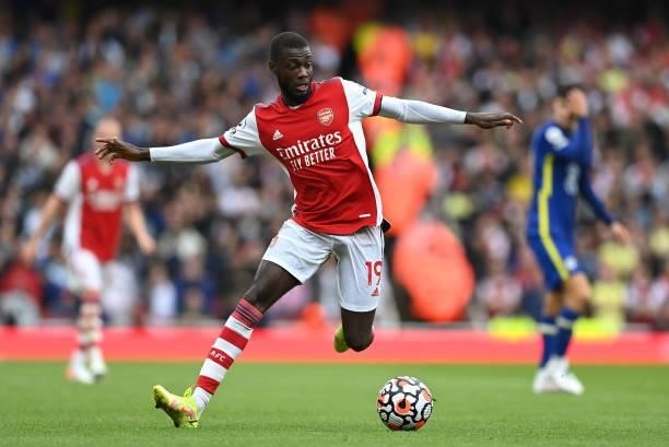 Nicolas Pepe of Arsenal runs with the ball during the Premier League match between Arsenal and Chelsea at Emirates Stadium on August 22, 2021 in...