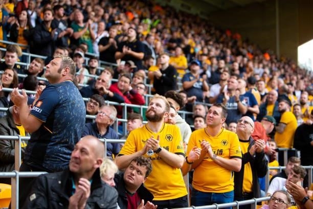 Fans are seen applauding as Wolverhampton Wanderers pay tribute to those who lost their lives during the COVID pandemic during the Premier League...