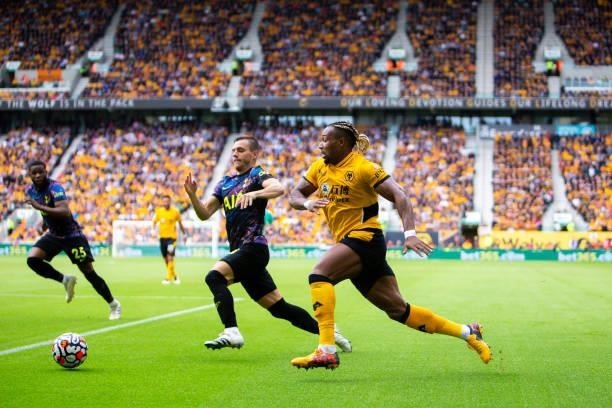 Adama Traore of Wolverhampton Wanderers runs with the ball under pressure from Giovani Lo Celso of Tottenham Hotspur during the Premier League match...