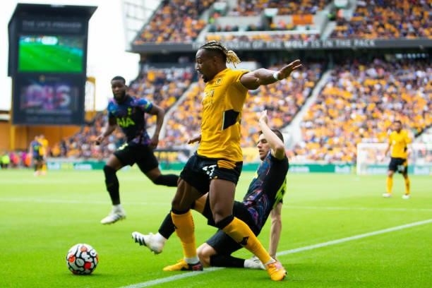 Adama Traore of Wolverhampton Wanderers is challenged by Giovani Lo Celso of Tottenham Hotspur during the Premier League match between Wolverhampton...