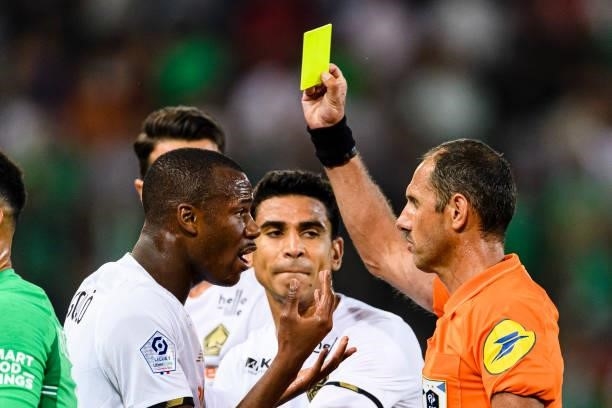 Referee Mikael Lesage shows a yellow card for Tiago Djalo of Lille during the Ligue 1 Uber Eats match between Saint Etienne and Lille at Stade...