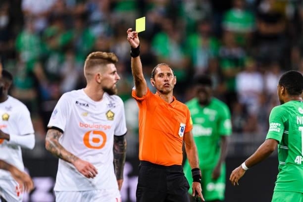 Referee Mikael Lesage shows a yellow card for Miguel da Silva Xeka of Lille during the Ligue 1 Uber Eats match between Saint Etienne and Lille at...