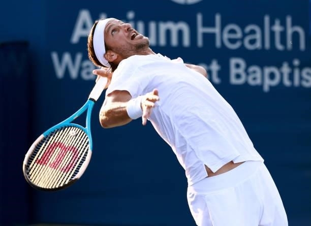 Lucas Pouille of France serves to Feliciano Lopez of Spain on Day 3 during the Winston-Salem Open at Wake Forest Tennis Complex on August 23, 2021 in...