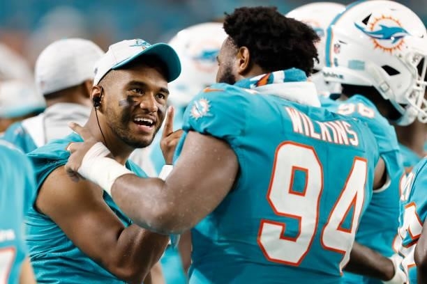 Tua Tagovailoa of the Miami Dolphins talks with Christian Wilkins against the Atlanta Falcons during a preseason game at Hard Rock Stadium on August...