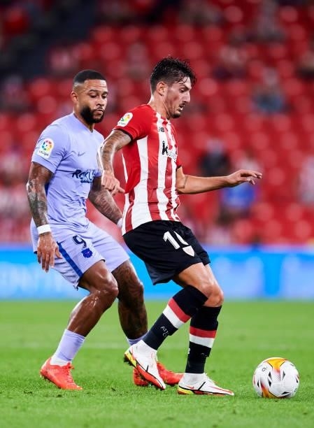 Memphis Depay of FC Barcelona duels for the ball with Unai Vencedor of Athletic Club during the LaLiga Santander match between Athletic Club and FC...