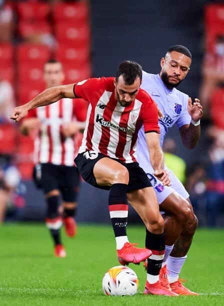 Memphis Depay of FC Barcelona duels for the ball with Inigo Lekue of Athletic Club during the LaLiga Santander match between Athletic Club and FC...