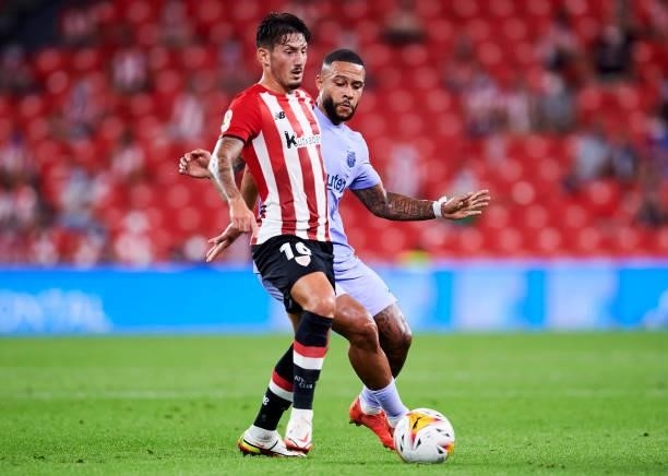 Memphis Depay of FC Barcelona duels for the ball with Unai Vencedor of Athletic Club during the LaLiga Santander match between Athletic Club and FC...