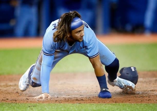 Bo Bichette of the Toronto Blue Jays scores a run on a double by Vladimir Guerrero Jr. #27 in the sixth inning during a MLB game against the Chicago...