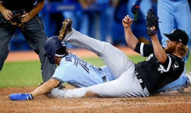 Breyvic Valera of the Toronto Blue Jays scores the winning run on a wild pitch by Craig Kimbrel of the Chicago White Sox in the eighth inning during...