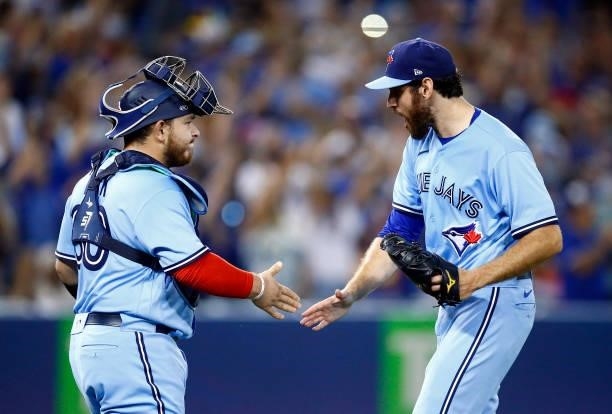 Jordan Romano of the Toronto Blue Jays celebrates the win with Alejandro Kirk following the ninth inning during a MLB game against the Chicago White...