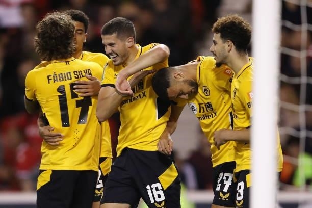 Romain Saiss of Wolverhampton Wanderers is congratulated by teammates Conor Coady and Rayan Ait-Nouri after scoring their team's first goal during...