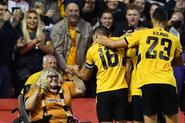 Wolverhampton Wanderers fan celebrates with with Conor Coady of Wolverhampton Wanderers and teammates after their team's first goal scored by Romain...