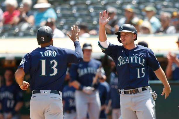 Abraham Toro and Kyle Seager of the Seattle Mariners celebrate after scoring on a single by Luis Torrens in the top of the third inning against the...