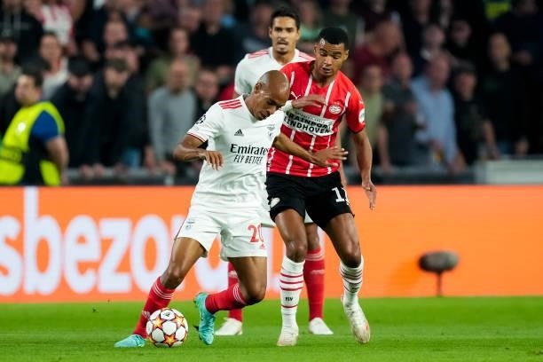 Joao Mario of Benfica and Cody Gakpo of PSV battle for possession during the UEFA Champions League Play-Offs Leg Two match between PSV and Benfica at...