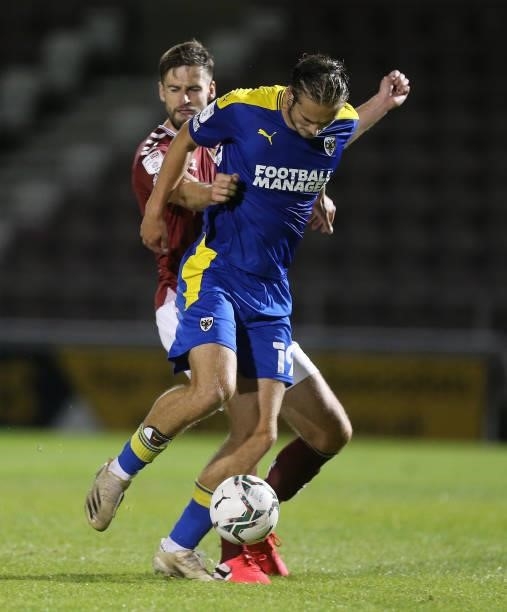 Aaron Pressley of AFC Wimbledon attempts to control the ball under pressure from Jon Guthrie of Northampton Town during the Carabao Cup 2nd Round...