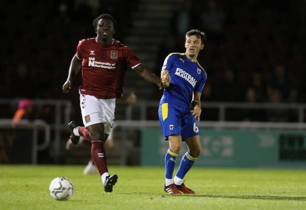 George Marsh of AFC Wimbledon plays the ball away from Benny Ashley-Seal of Northampton Town during the Carabao Cup 2nd Round match between...
