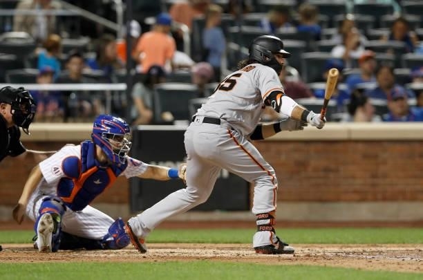 Brandon Crawford of the San Francisco Giants follows through on a fourth inning RBI single against the New York Mets at Citi Field on August 24, 2021...