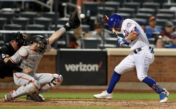 Curt Casali of the San Francisco Giants tries to catch the ball after it hit J.D. Davis of the New York Mets during the ninth inning at Citi Field on...