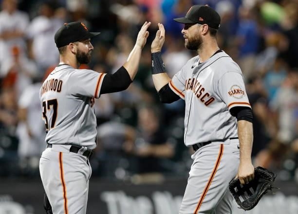 Tyler Chatwood and Brandon Belt of the San Francisco Giants celebrate after defeating the New York Mets at Citi Field on August 24, 2021 in New York...