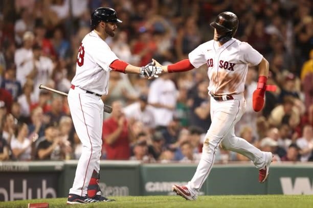 Enrique Hernandez of the Boston Red Sox high fives J.D. Martinez of the Boston Red Sox after scoring during a game against the Minnesota Twins at...