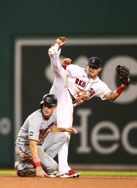 Enrique Hernandez of the Boston Red Sox turns a double play over the incoming slide of Max Kepler of the Minnesota Twins during the sixth inning of a...