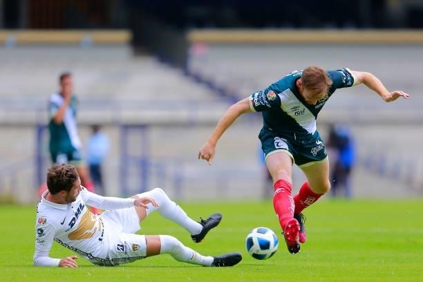 Arturo Ortiz of Pumas fights for the ball with Fernando Luis Aristeguieta of Puebla during the 6th round match between Pumas UNAM and Puebla as part...