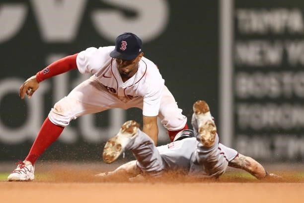Xander Bogaerts of the Boston Red Sox tags a runner out at second base during a game against the Minnesota Twins at Fenway Park on August 24, 2021 in...