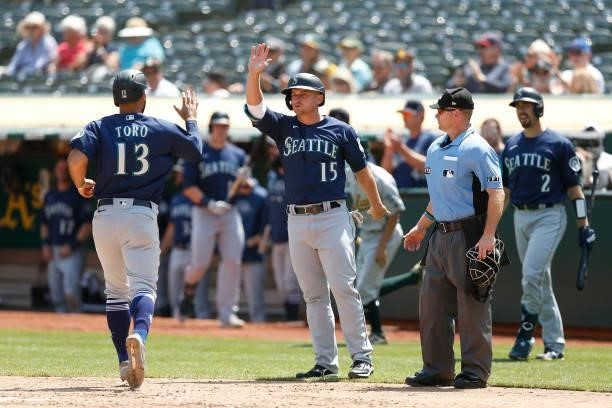 Abraham Toro and Kyle Seager of the Seattle Mariners celebrate after scoring on a single by Luis Torrens in the top of the third inning against the...