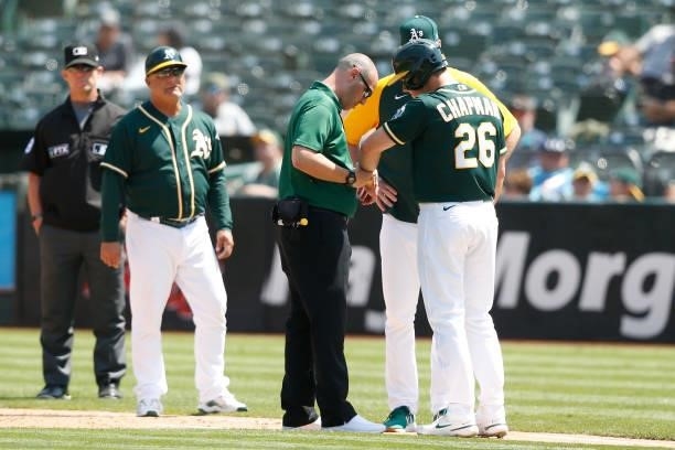 Matt Chapman of the Oakland Athletics is evaluated after being hit by a pitch in the bottom of the fourth inning against the Seattle Mariners at...