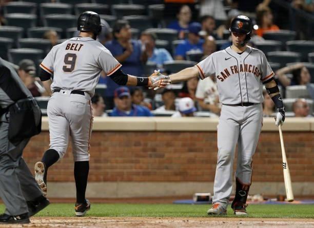 Brandon Belt of the San Francisco Giants celebrates his fourth inning home run against the New York Mets with teammate Buster Posey at Citi Field on...
