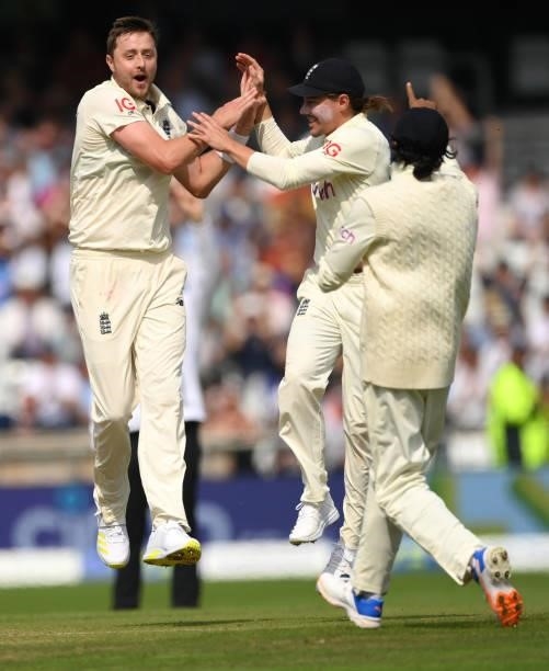 England bowler Ollie Robinson celebrates with team mates after taking the wicket of Rahane during day one of the Third Test Match between England and...